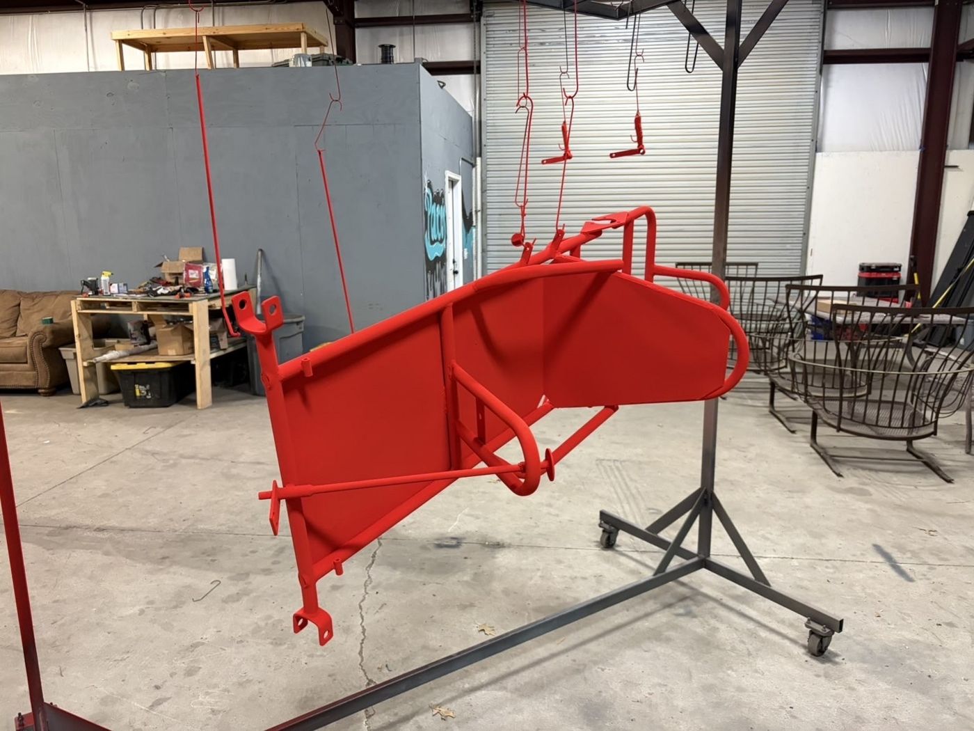Red powder coated equipment frame hanging in the Paco's shop